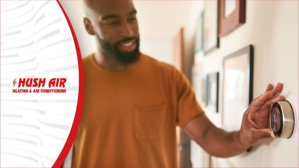 A man adjusting his smart thermostat